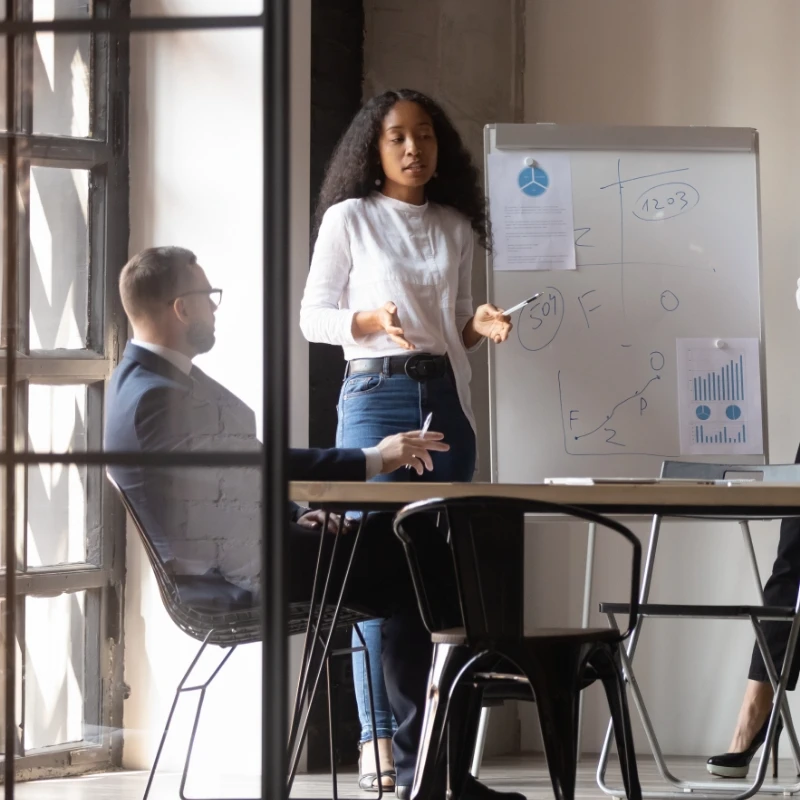 a woman giving a presentation to the rest of the group