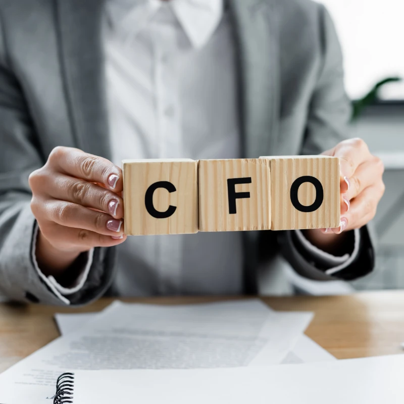 a person holding blocks that spell CFO